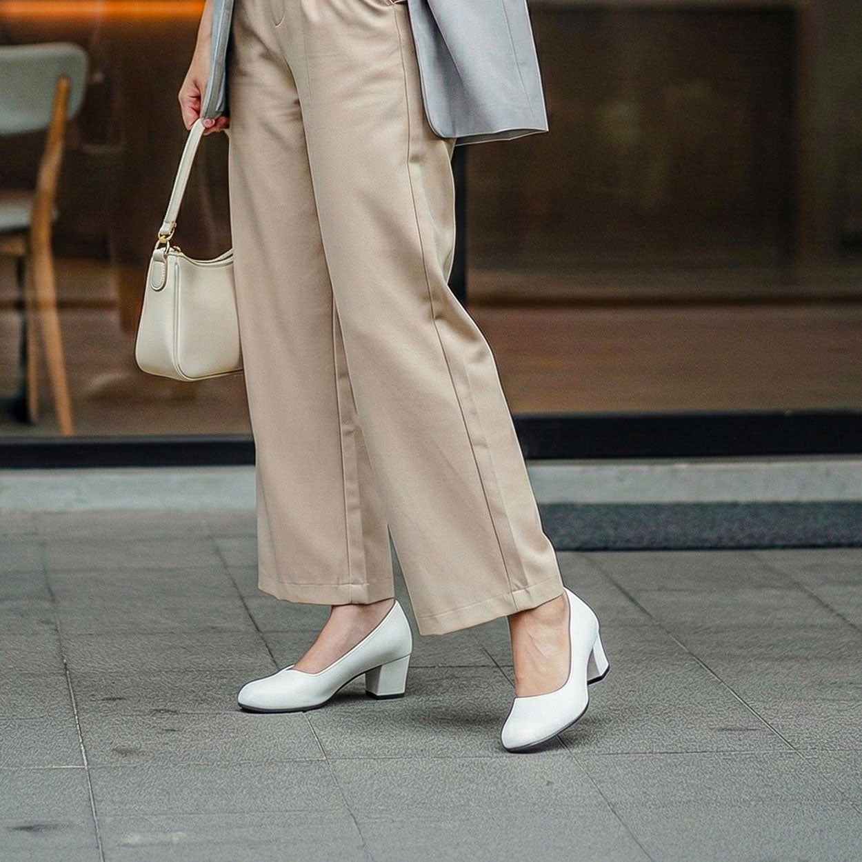 Person wearing beige pants and white shoes with a blurred background